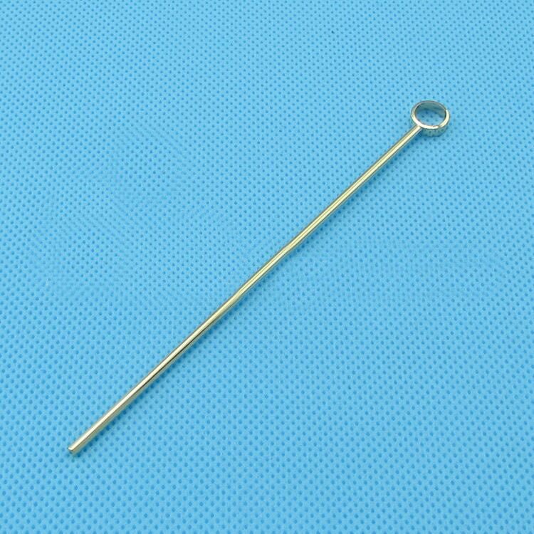 Gold-colored eye pin for jewelry making on blue textured background
