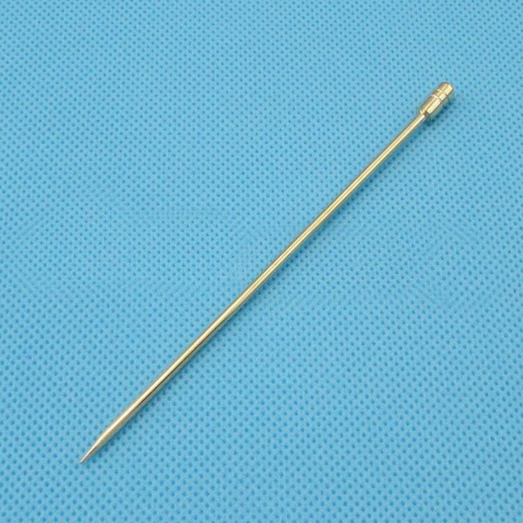 Golden metal skewer for grilling or serving, ideal kitchen tool on blue textured background