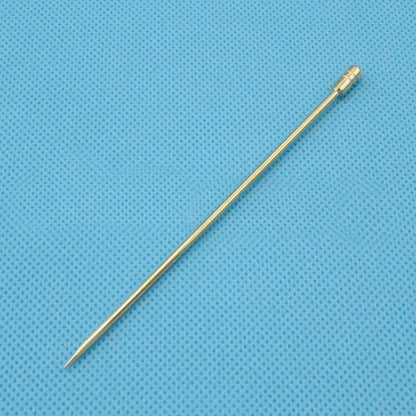 Golden metal skewer for grilling or serving, ideal kitchen tool on blue textured background