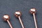 Copper ball-ended body jewelry pins for piercings, sleek and shiny, ideal for nose or ear studs