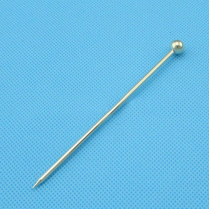Gold ball head pin for jewelry making and crafting on blue textured background