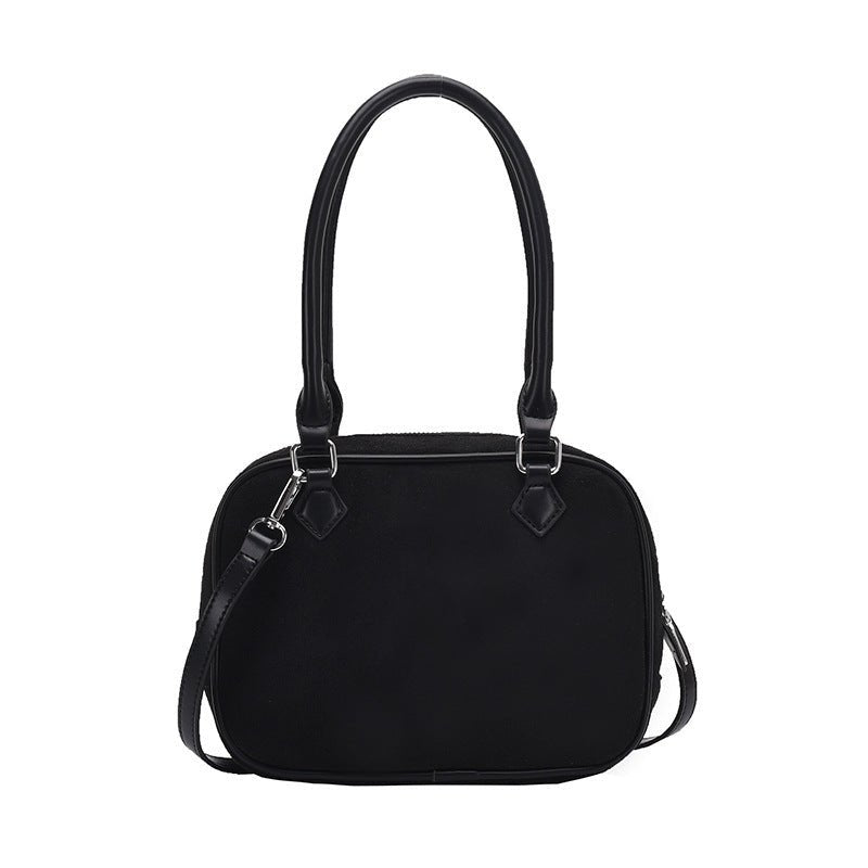 Black dome-shaped handbag with top handles and detachable shoulder strap, stylish fashion accessory