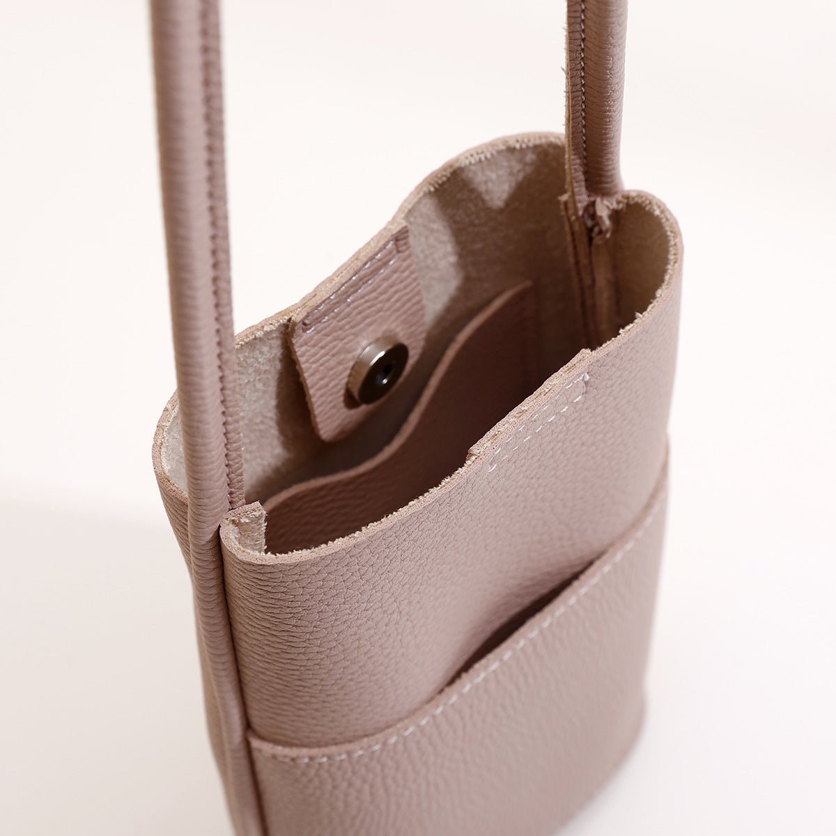 Beige textured leather crossbody bag with snap button closure and interior pocket, ideal for everyday fashion