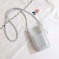 Silver textured crossbody bag with floral embroidered strap, stylish fashion accessory