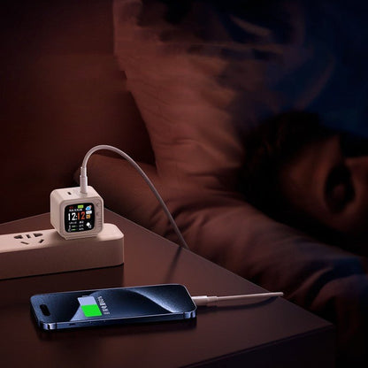 Smart digital alarm clock with USB charging port charging phone on bedside table at night