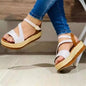 White espadrille platform sandals with ankle strap, worn with blue jeans for casual summer fashion